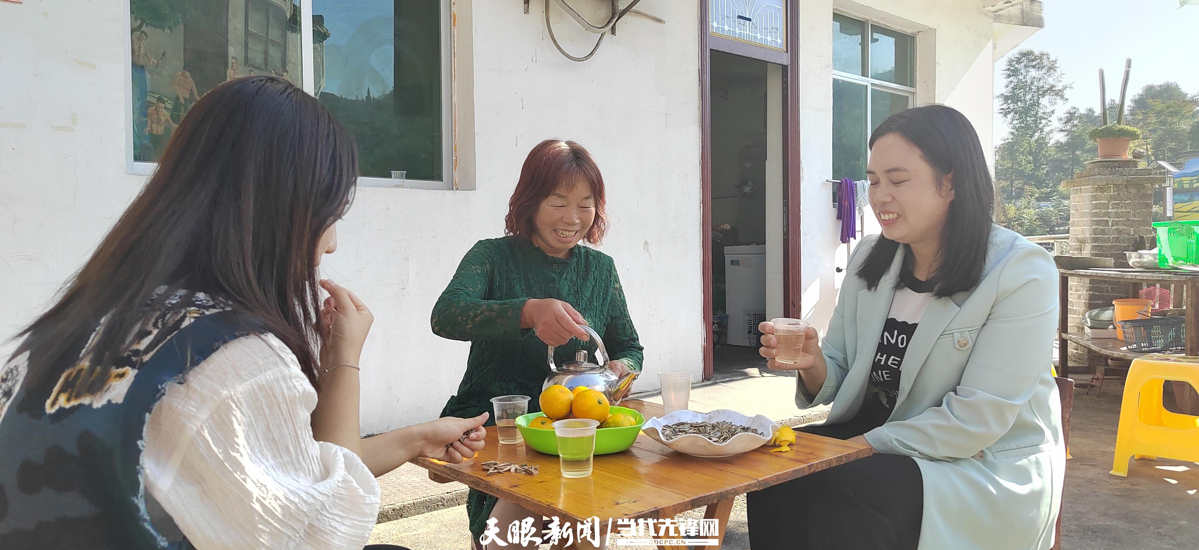 銅仁市萬山區(qū)青年湖村黃家寨農家樂老板龍福珍（中）正與游客聊天喝茶。吳采麗 攝.jpg