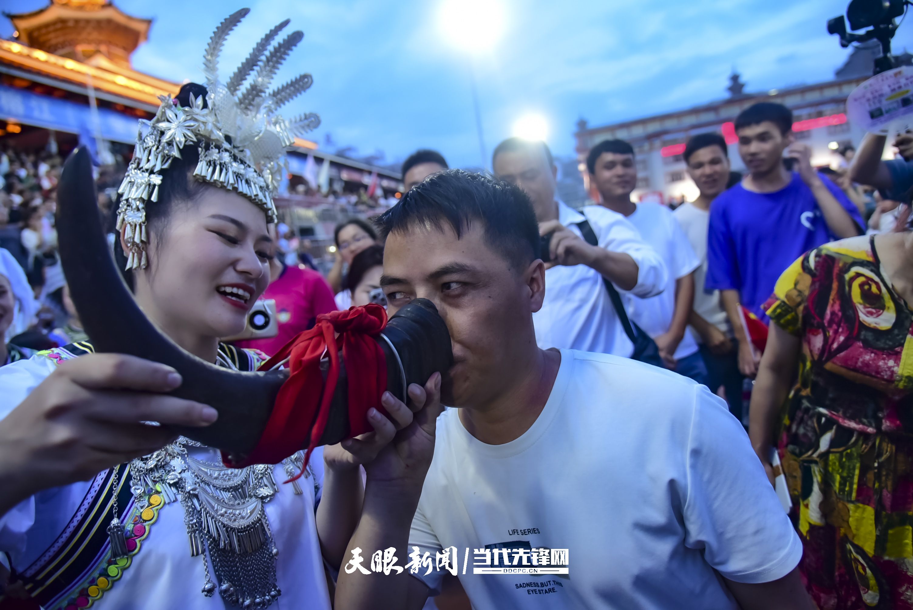 村超現(xiàn)場，當?shù)厝罕娤蜻h道而來的游客敬酒。 潘邵平 攝.jpg