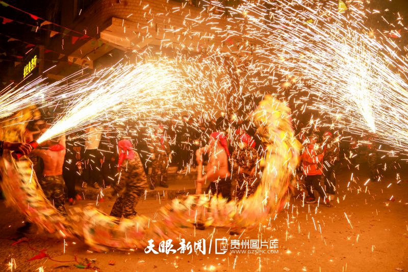 709641-2月18日，在遵義市播州區(qū)芶江鎮(zhèn)非遺民宿舞龍慶新春文化活動上，群眾向玩龍愛好者噓花、燃放鞭炮。.jpg